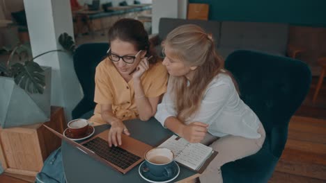 dos mujeres colaborando en una cafetería