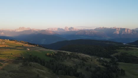 Toma-Aérea-De-Drones-De-Los-Alpes-Mientras-Se-Pone-El-Sol-Con-Cabañas-Y-Tierras-De-Cultivo,-Hermosa-Naturaleza