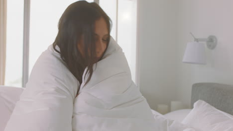 happy-woman-playing-in-bed-having-fun-under-sheets-enjoying-carefree-morning-at-home