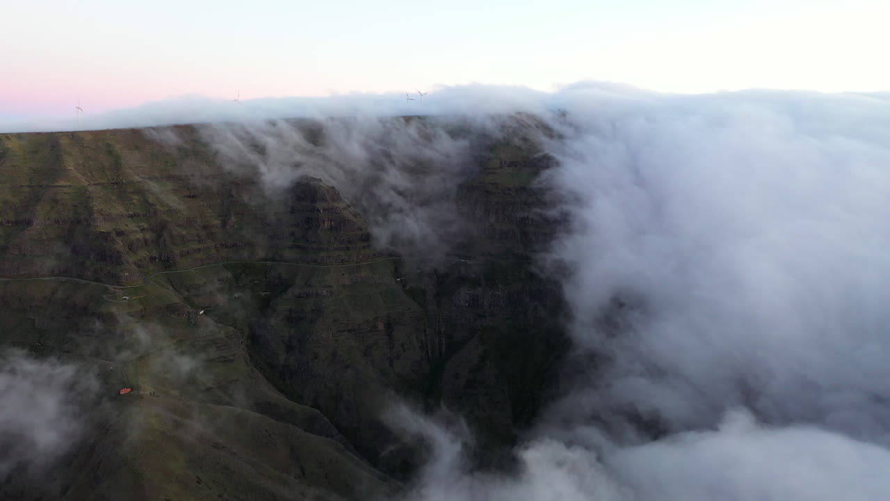 imágenes aéreas de drones de nubes rodando desde una montaña en la isla de madeira, portugal