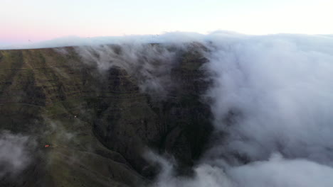 drone aerial footage of clouds rolling off a mountain on the island of madeira, portugal