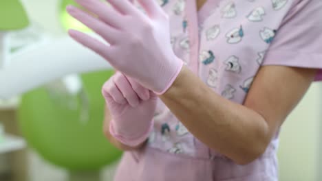 close up doctor hands putting on surgical gloves. woman dentist hands