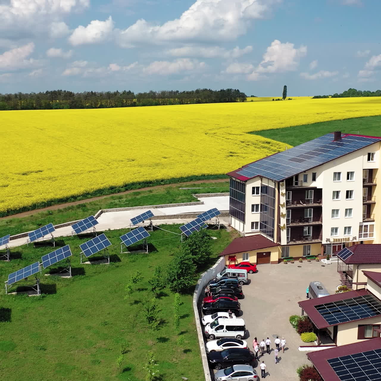 Modern buildings with solar panels on roof on the background of golden field. Solar panels on the roof of private houses, the extraction of electricity by solar panels. Aerial view.