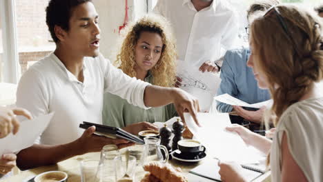 small business start-up meeting in cafe architectural sketch planning mixed race team