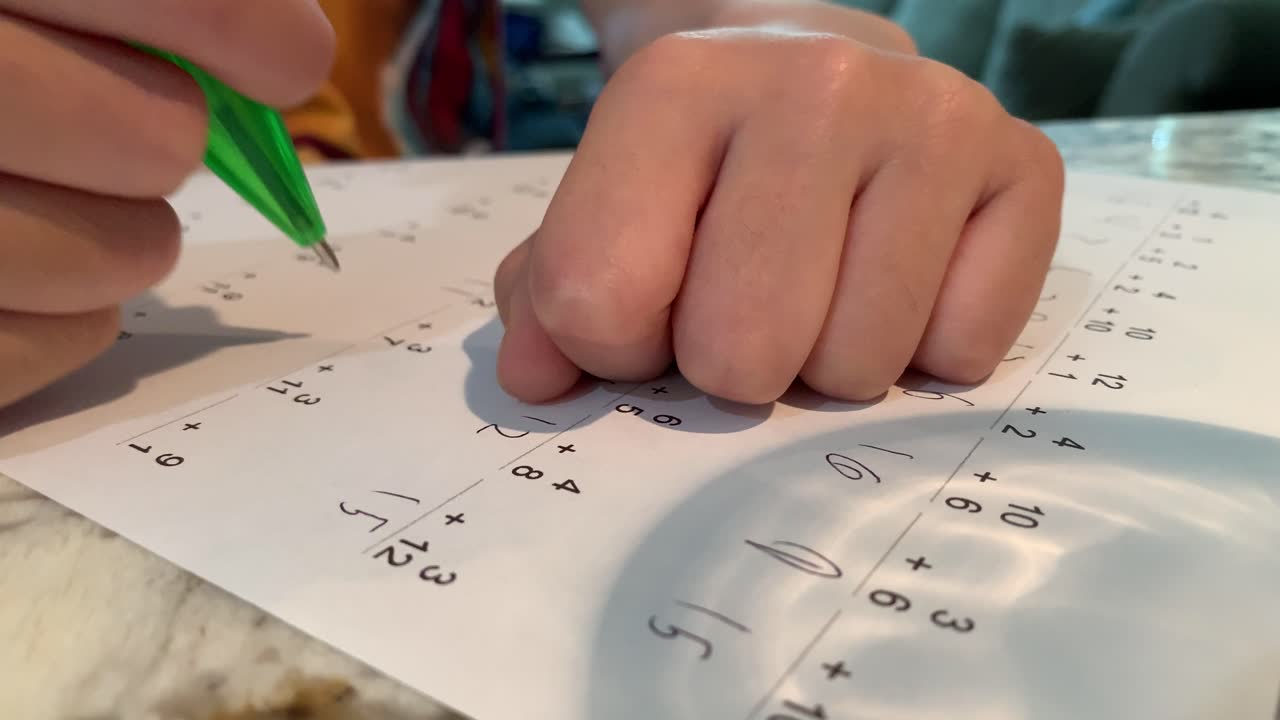 estudiante de primaria haciendo matemáticas en una hoja de trabajo de práctica
