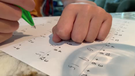 elementary aged student doing math on a practice worksheet