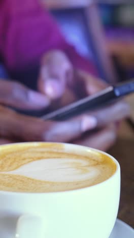 person using smartphone and enjoying coffee