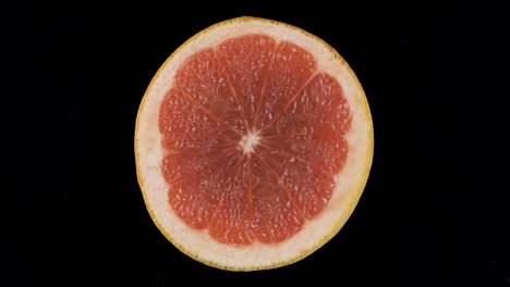 rotation of a slice of grapefruit on a black background.