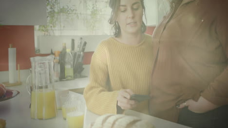 using smartphone, person in kitchen with juice and bread, other watching animation