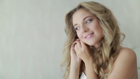 bride wearing jewelry. beautiful young bride with wedding makeup and hairstyle in bedroom