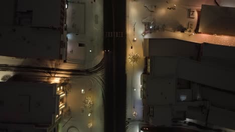 snow covered town street at night