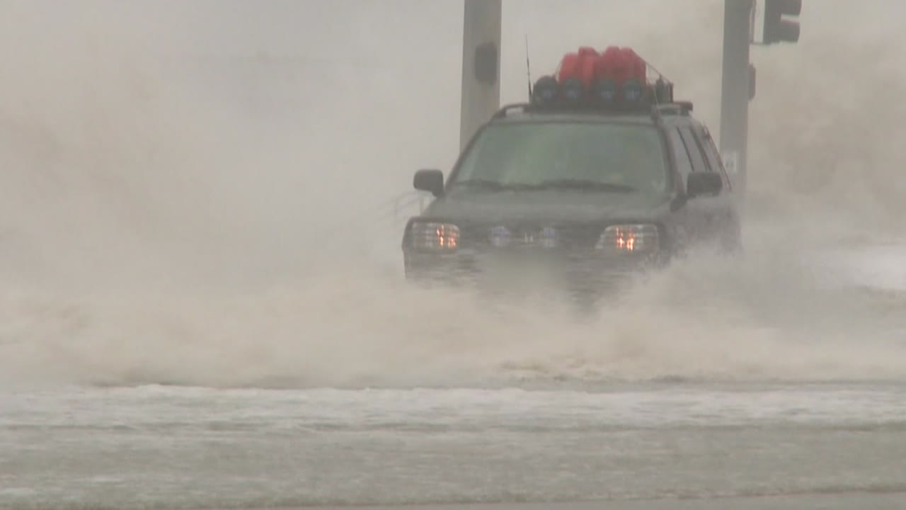 거대한 폭풍이나 허리케인으로 인한 홍수 동안 자동차가 깊은 물을 통과합니다.