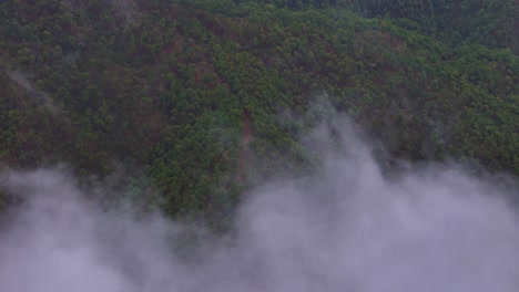 aerial drone shot capturing a quiet, cloud-blanketed morning in the highlands.