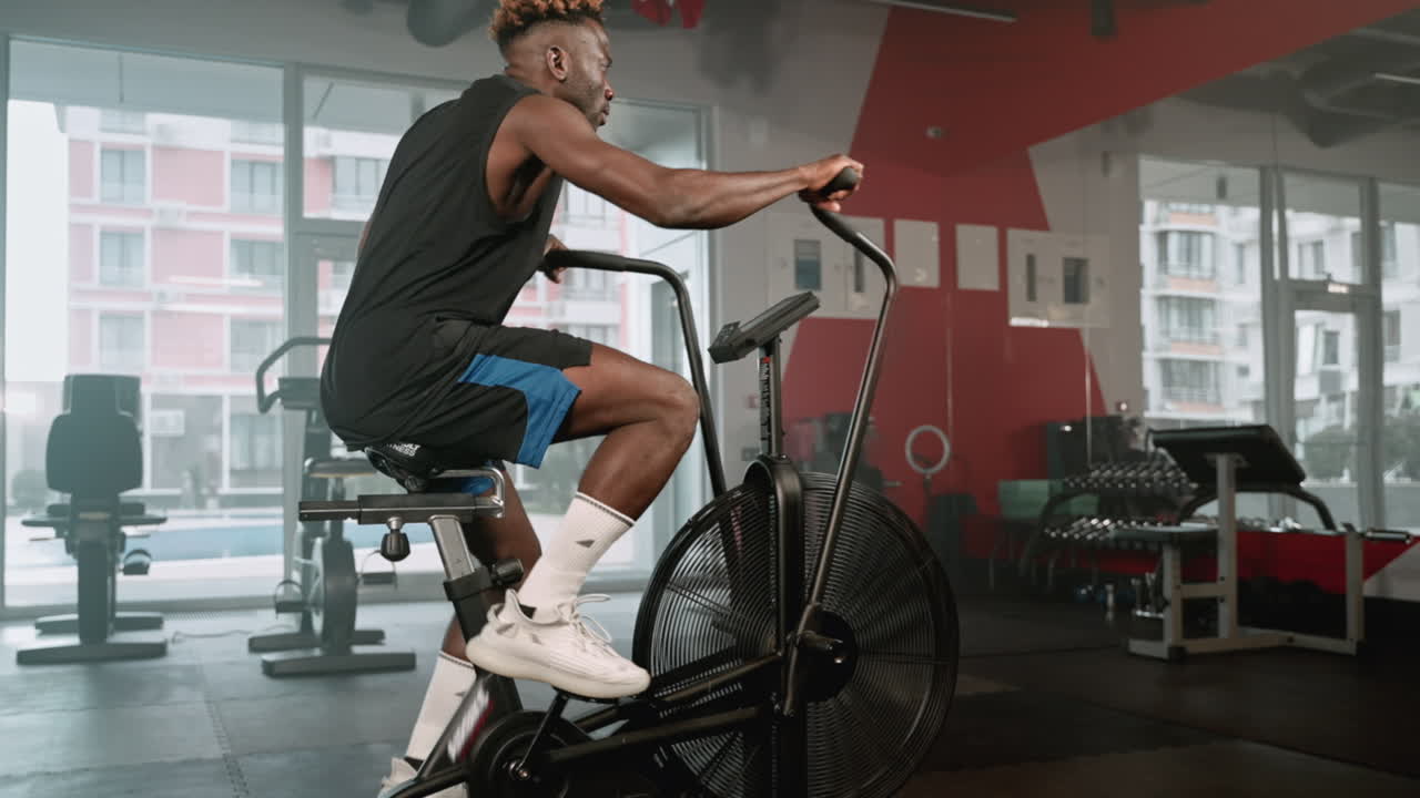 체육관 에서 공기 자전거 를 타고 운동 하는 사람