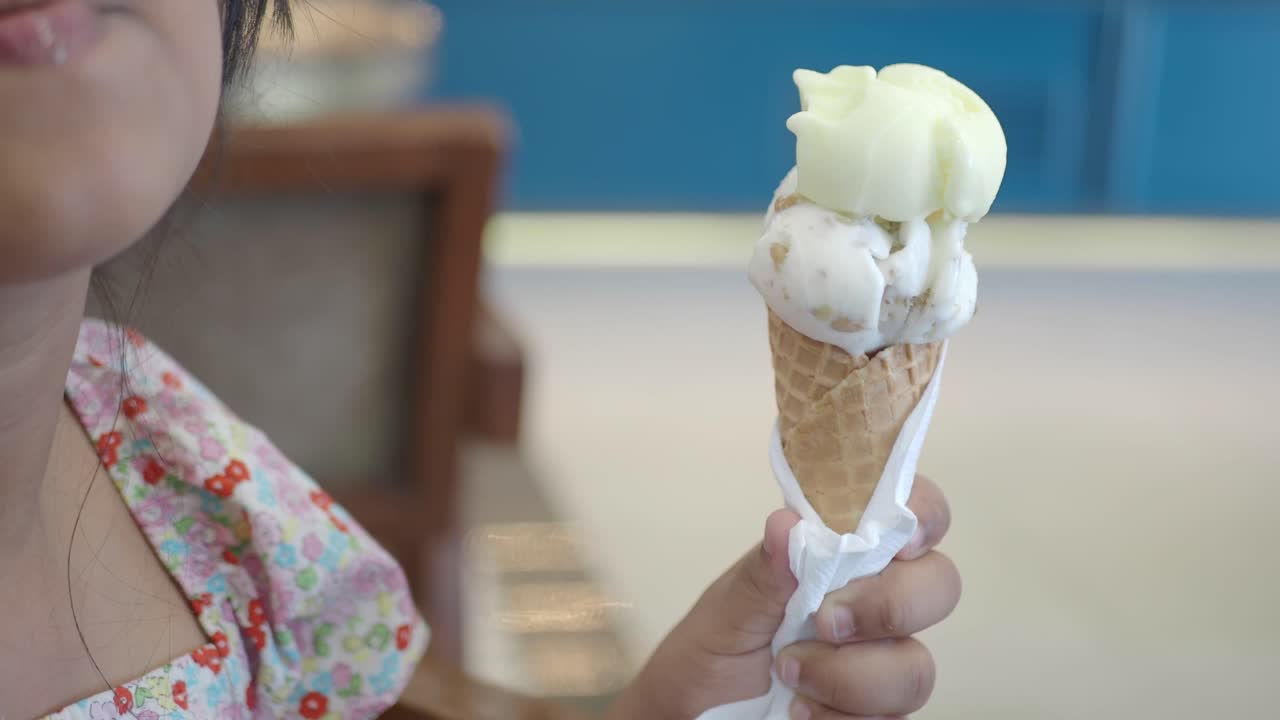 A person holding a two-scoop ice cream cone