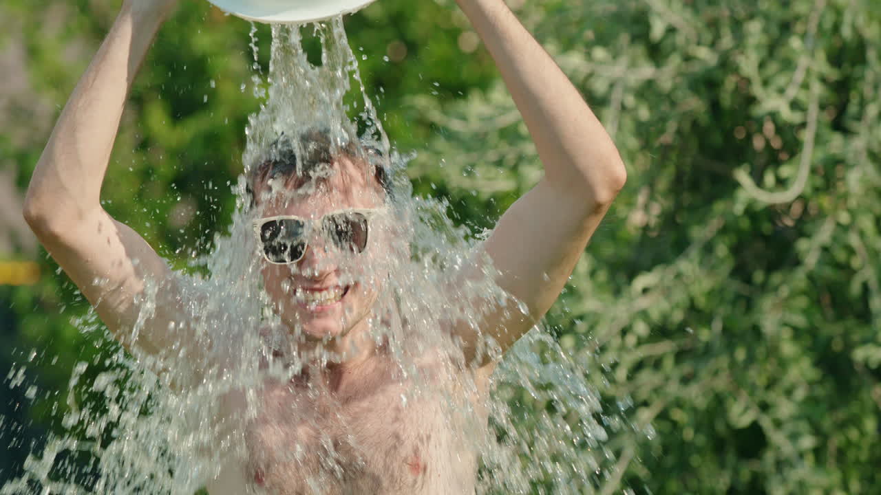 한 남자가 버에서 차가운 물로 어지고 있다.