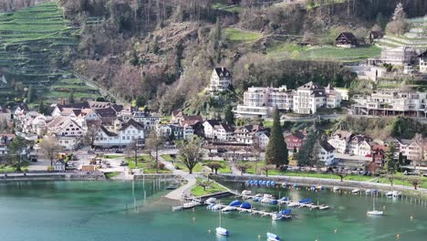 clip de avión no tripulado moviéndose hacia edificios tradicionales en weesen, st gallen, en la orilla del lago walen