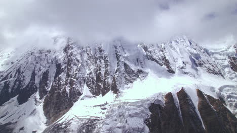 range of mountains in nepal filled with snow melts due to global warming, cloudy sky-covered drone shot 4k