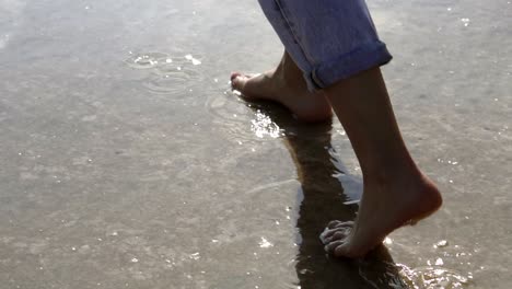 woman feet walking barefoot by lake or sea shore in lins flares