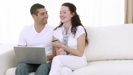 Young-Couple-at-home-using-a-laptop