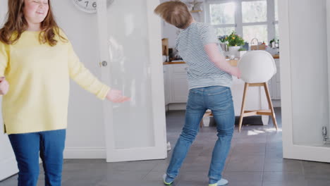 young downs syndrome couple having fun dancing at home together