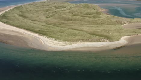 Vista-Aérea:-Marea-Saliente-Turbulenta-En-Las-Dunas-De-Arena-De-Tramore,-Irlanda