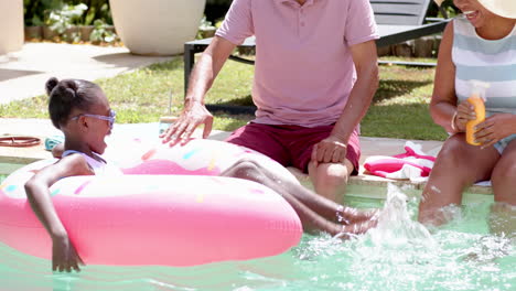diverse grandparents enjoying sunny day by pool, playfully interacting with grandchild