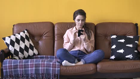 woman using a phone on a couch