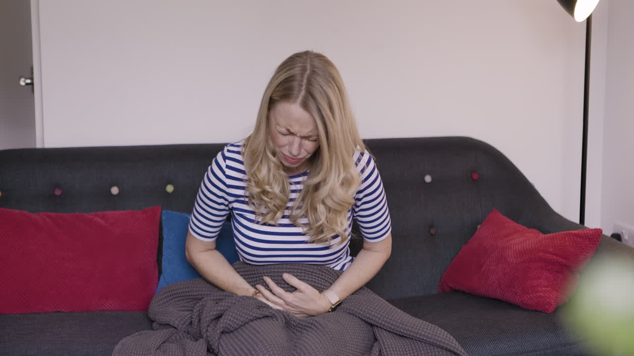 Woman on couch with stomach pain
