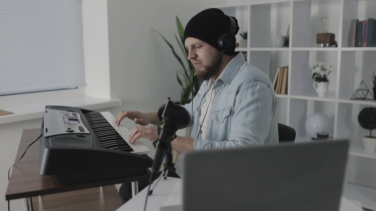 집에서 전기 키보드를 연주하고 노래하는 남성 음악가 1