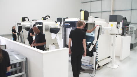 taller de ingeniería ocupado con máquinas cnc y operadores