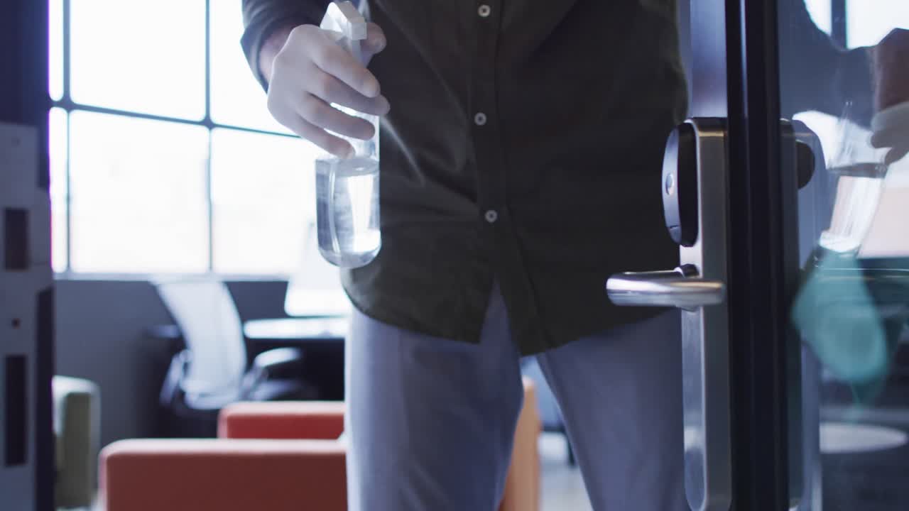 보호 의복 을 입은 사무실 청소원 들 이 현대적 인 사무실 공간 을 청소 하고 있다