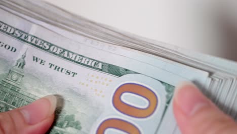 close up of female hands counting 100 american dollars in white background