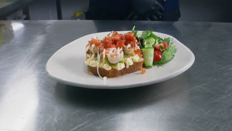 Der-Küchenchef-Fügt-Gurke-Zum-Toast-Mit-Rührei,-Avocado-Und-Gebratenen-Garnelen-Hinzu