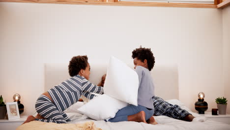 familia, pelea de almohadas y jugar en el dormitorio