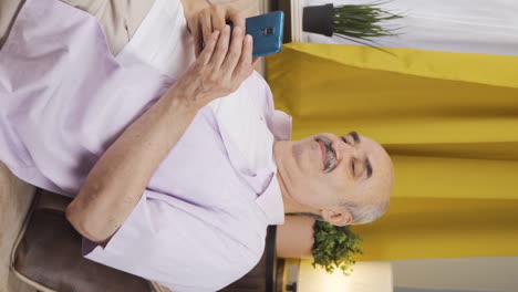 Vertical-video-of-Old-man-lying-on-the-sofa-is-resting.