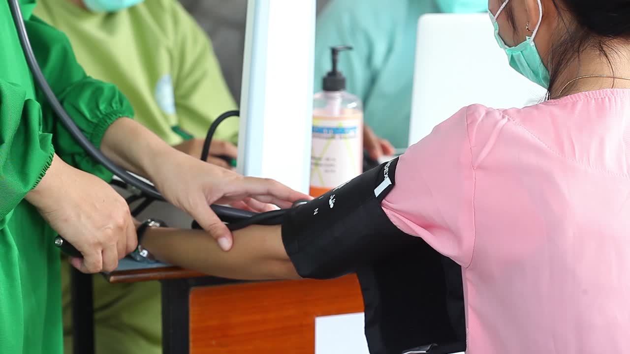 Yogyakarta, Indonesia - Feb 15, 2021 : female health workers at a hospital is being checked his blood pressure before injected the corona virus vaccine