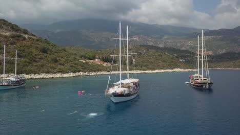 caucasian male tourist swan dives off bowsprit of moored tourist ship