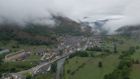 A-serene-and-gradual-drone-movement-offers-a-gentle-tilt-to-unveil-the-entire-Spanish-town-nestled-within-the-lofty-Pyrenees-mountains,-captured-from-a-high-altitude-perspective