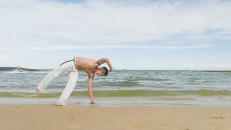 Mann-Tanzt-Capoeira-Am-Strand