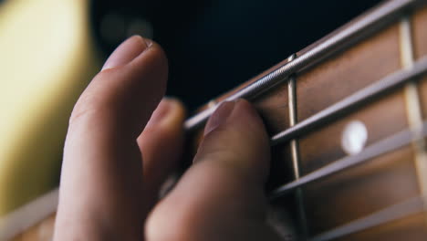 Profesor-De-Música-Toca-El-Bajo-Presionando-Cuerdas-De-Metal