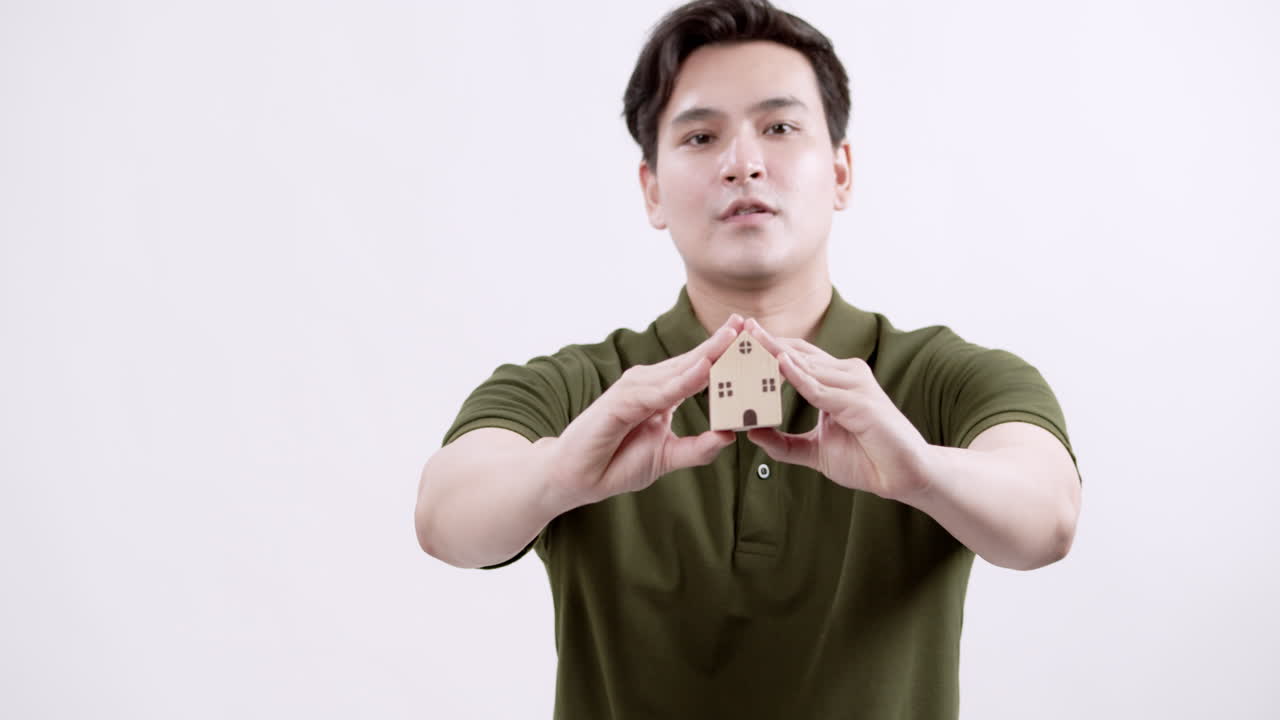 A real estate agent showcases a miniature house emphasizing the importance of home ownership in a vibrant office setting.