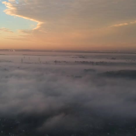 Above-low-clouds-sunrise-with-pylons-coming-out-of-the-mist