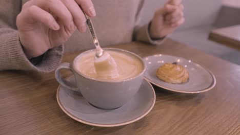 woman enjoying coffee and pastry in a cafe