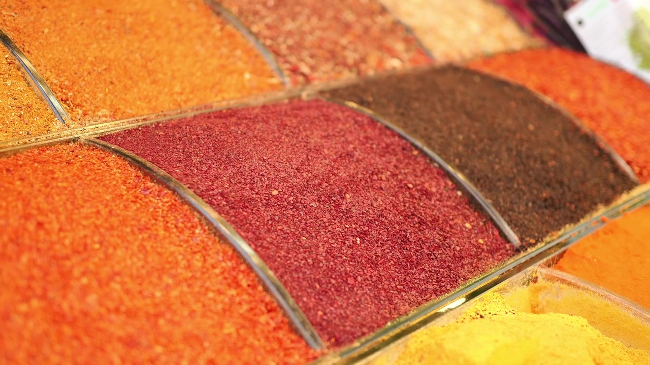 Assortimento vivace di spezie e condimenti colorati esposti in un mercato