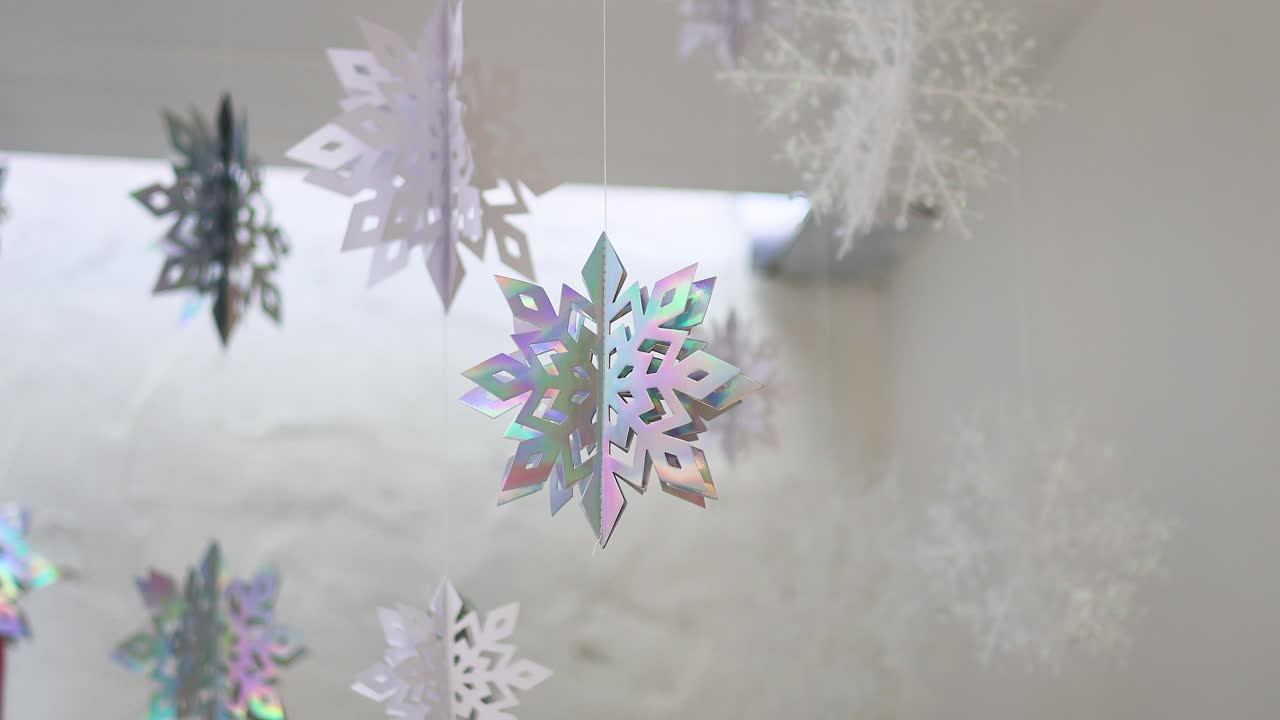 白い背景をバックに舞い散るカラフルな雪の結晶