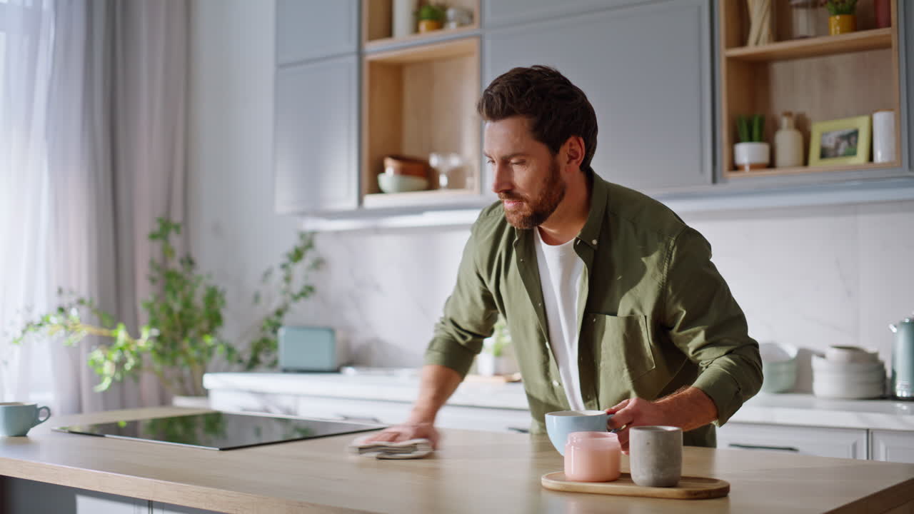 Man cleaning kitchen countertop enjoying daily housekeeping routine closeup