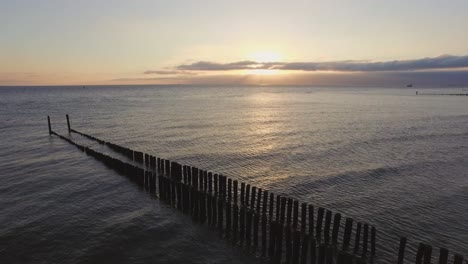 Aerial:-Wave-breakers-on-a-beach-in-Zeeland,-the-Netherlands