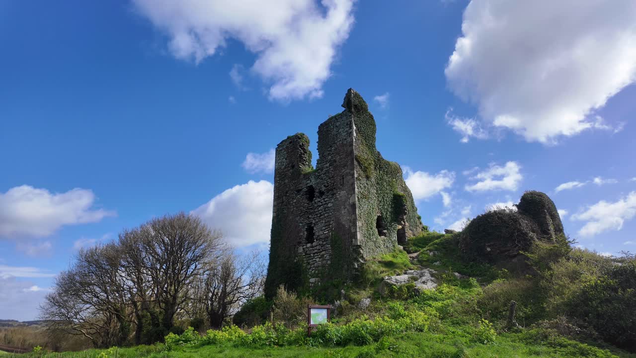 워터포드 (waterford) 에 있는 언덕 위에 있는 던힐 성 (dunhill castle) 의 황홀한 유적들은 푸른 하늘과  구름이 흐르는 밝은 빛의 날, 크롬웰에 의해 파괴되고 다시는 재건되지 않은 성 (castle) 을 지나간다.