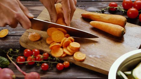 Cutting-carrots-with-a-knife,-still-shot-of-a-woman-preparing-vegetables-while-cooking-a-healthy-dish